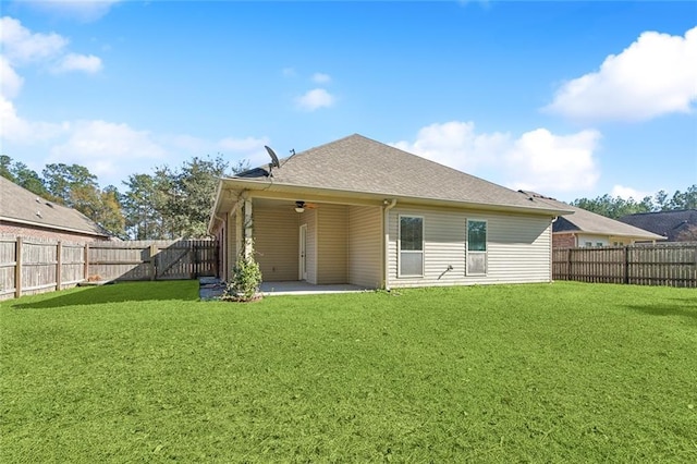 back of property with a yard, a patio, and ceiling fan