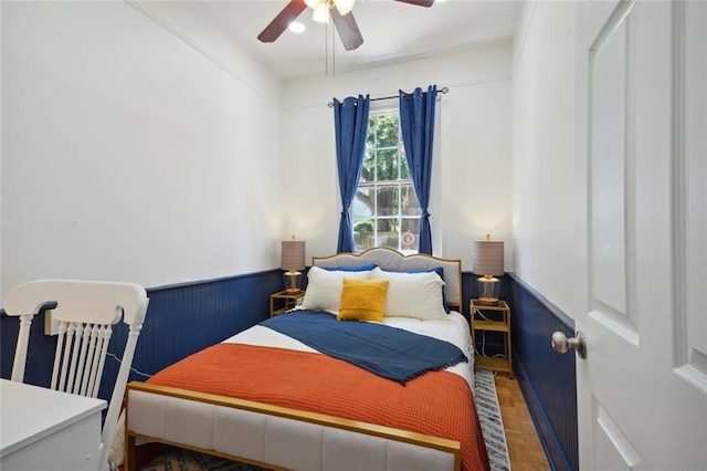 bedroom with ceiling fan and parquet flooring