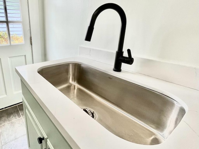 room details featuring green cabinetry and sink