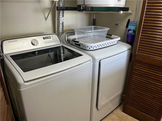 clothes washing area featuring light tile patterned flooring and washing machine and clothes dryer