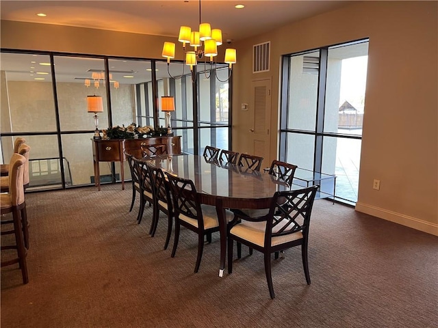 dining area featuring dark colored carpet and a chandelier