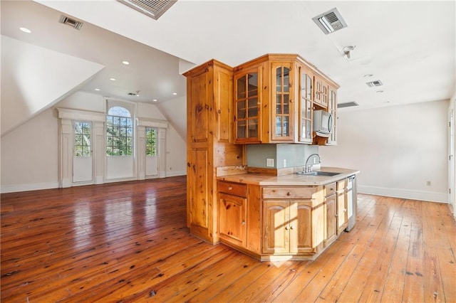 kitchen with light hardwood / wood-style floors, sink, and vaulted ceiling