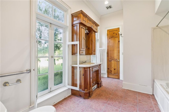 bathroom featuring tile patterned floors, a wealth of natural light, vanity, and a bath