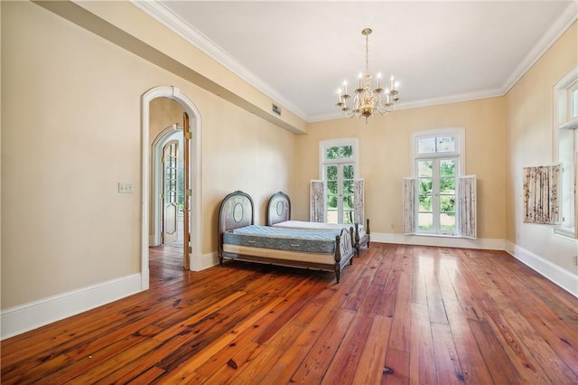 bedroom with ornamental molding, a notable chandelier, and hardwood / wood-style floors