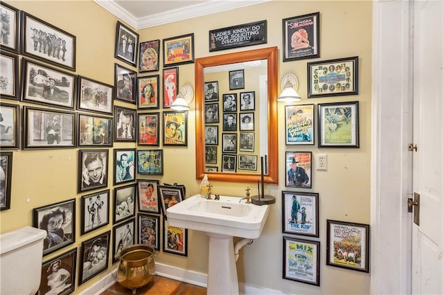 bathroom featuring toilet and crown molding