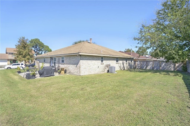 rear view of house featuring a lawn, a patio area, and cooling unit