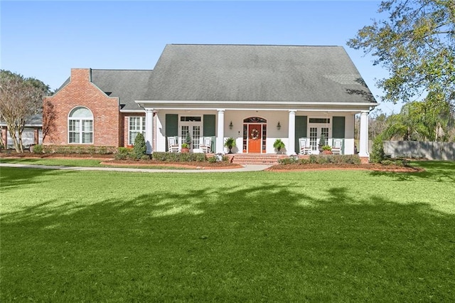 cape cod house featuring a front yard, french doors, and covered porch