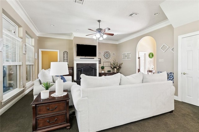 living room featuring dark colored carpet, ceiling fan, and ornamental molding