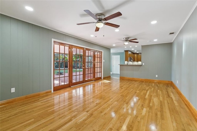 unfurnished living room featuring ceiling fan, french doors, and light hardwood / wood-style flooring