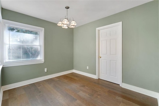 unfurnished room featuring a chandelier and hardwood / wood-style floors