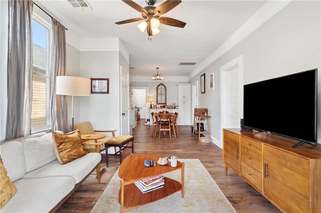 living room with ceiling fan with notable chandelier and dark wood-type flooring