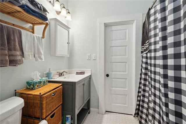 bathroom featuring tile patterned flooring, vanity, and toilet