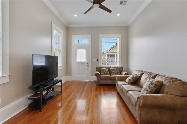 living room featuring ceiling fan, hardwood / wood-style floors, and crown molding