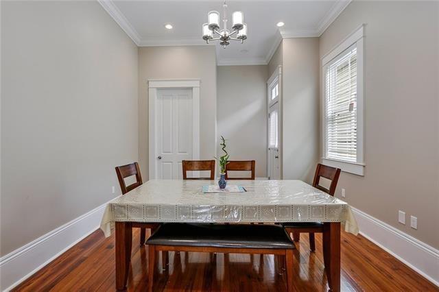 dining room with dark hardwood / wood-style floors, an inviting chandelier, and ornamental molding