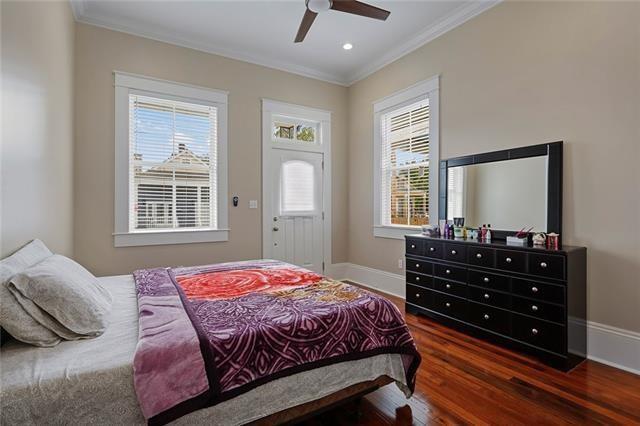 bedroom with ceiling fan, dark wood-type flooring, and ornamental molding