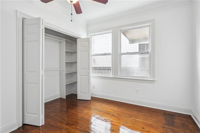 unfurnished bedroom with ceiling fan, a closet, crown molding, and dark hardwood / wood-style floors