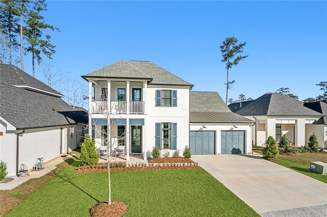 view of front of property featuring a balcony, a front yard, and a garage