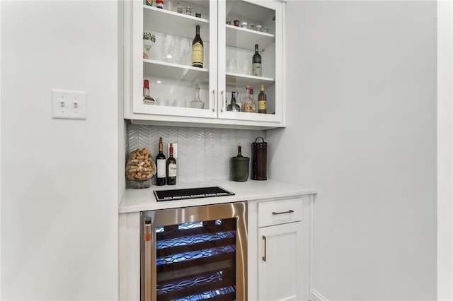 bar featuring white cabinets, backsplash, and wine cooler