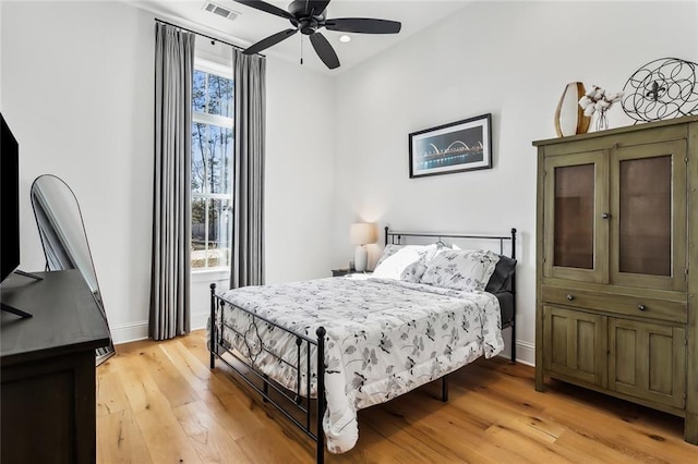 bedroom with multiple windows, ceiling fan, and light hardwood / wood-style floors