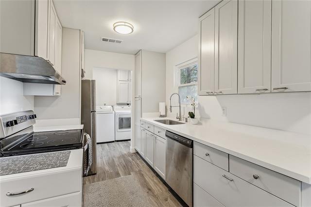 kitchen with white cabinets, sink, electric range, dishwasher, and washing machine and dryer