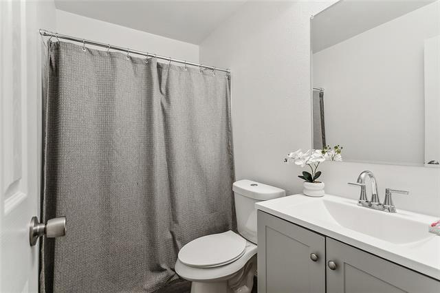 bathroom with a shower with curtain, vanity, and toilet