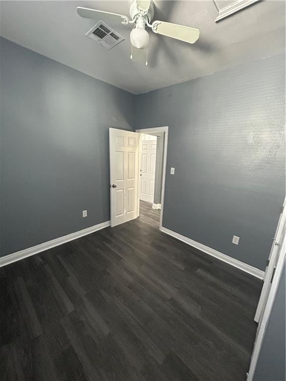 empty room with ceiling fan and dark hardwood / wood-style floors