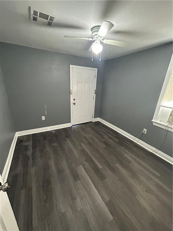 unfurnished room featuring a textured ceiling, ceiling fan, and dark hardwood / wood-style floors