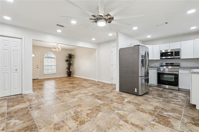 kitchen with stainless steel appliances, white cabinetry, ceiling fan, and light stone counters