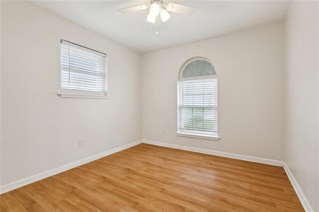 empty room with ceiling fan and light hardwood / wood-style floors