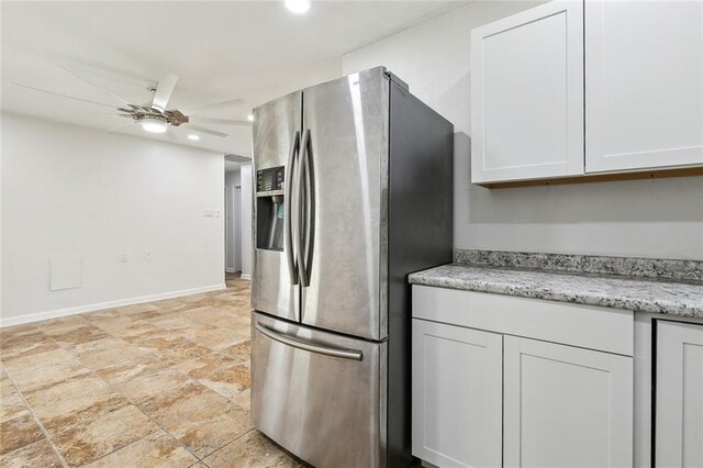 kitchen featuring stainless steel refrigerator with ice dispenser, light stone countertops, white cabinetry, and ceiling fan