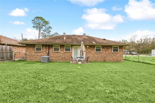 back of house featuring a yard and central AC unit