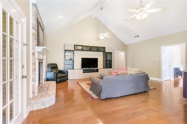 living room with beam ceiling, ceiling fan, high vaulted ceiling, and light wood-type flooring