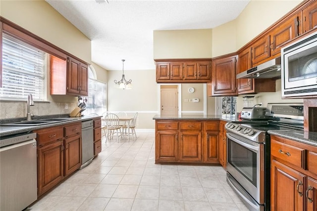 kitchen featuring stainless steel appliances, extractor fan, sink, pendant lighting, and a chandelier