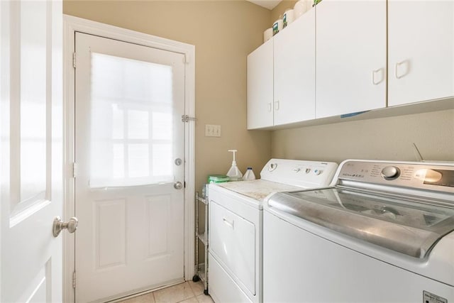 washroom featuring cabinets, light tile patterned floors, and washing machine and dryer