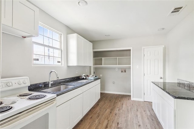 kitchen featuring light hardwood / wood-style flooring, sink, white cabinetry, electric stove, and dark stone countertops