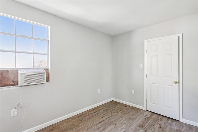 empty room featuring cooling unit and light hardwood / wood-style floors