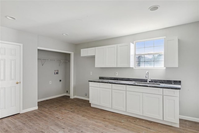 kitchen with sink, white cabinetry, and light hardwood / wood-style flooring