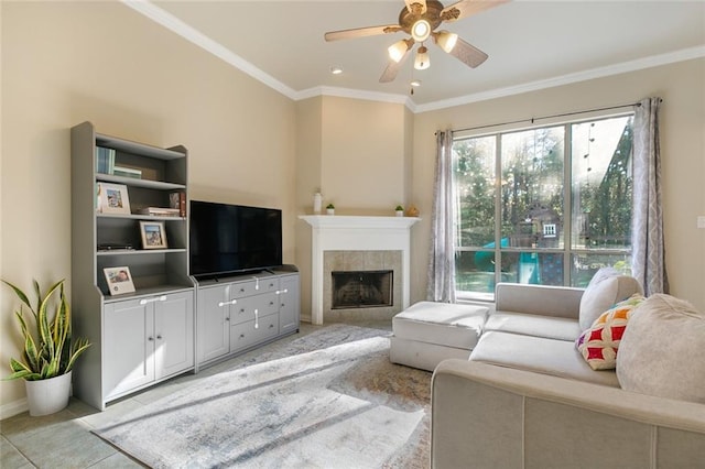 living room featuring ceiling fan, light tile patterned floors, crown molding, and a tile fireplace