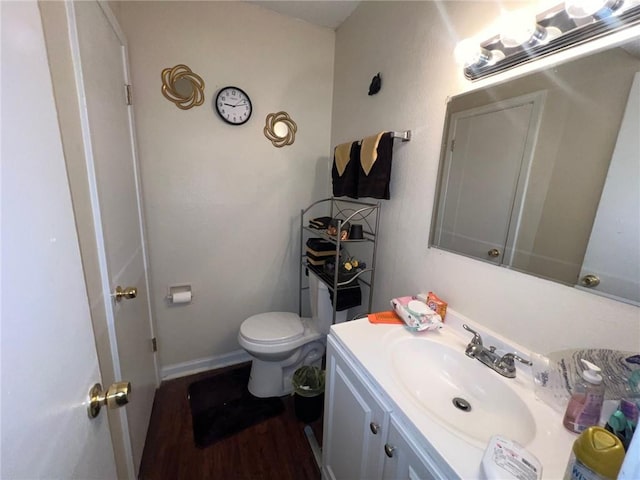 bathroom featuring wood-type flooring, vanity, and toilet