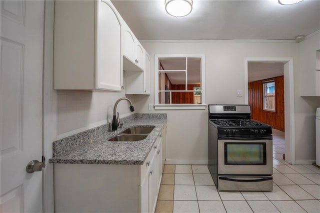 kitchen with white cabinets, light tile patterned flooring, stainless steel range with gas cooktop, and sink