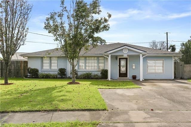 ranch-style house with fence, driveway, and a front yard
