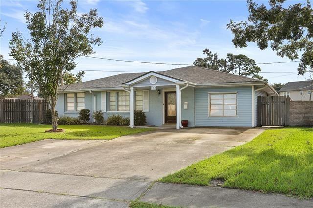 bungalow-style house featuring driveway, fence, and a front yard