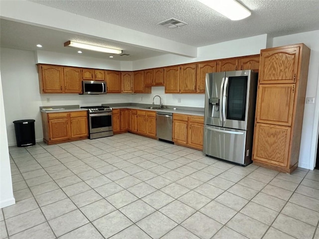kitchen featuring light countertops, visible vents, stainless steel appliances, and a sink