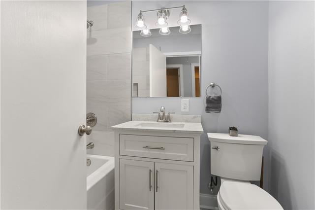 bathroom with shower / bath combination, toilet, and vanity