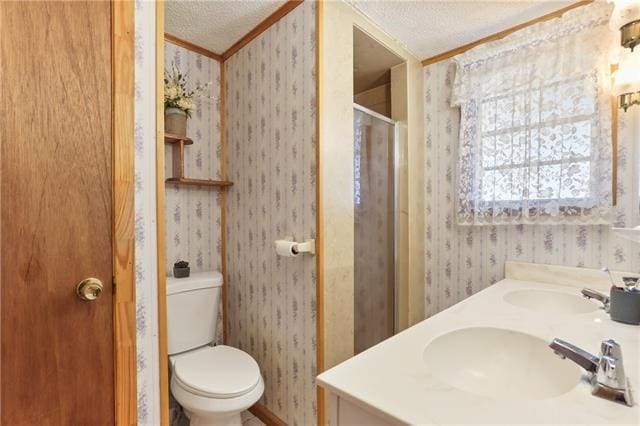 full bath featuring a sink, a textured ceiling, a stall shower, wallpapered walls, and ornamental molding