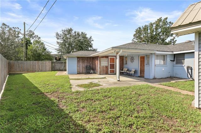 rear view of property with a lawn, a fenced backyard, and a patio
