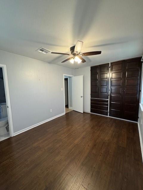 unfurnished bedroom with dark hardwood / wood-style flooring, ensuite bath, and ceiling fan