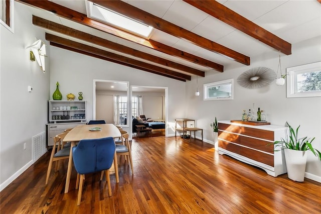 dining space with dark wood-type flooring, plenty of natural light, and lofted ceiling with beams