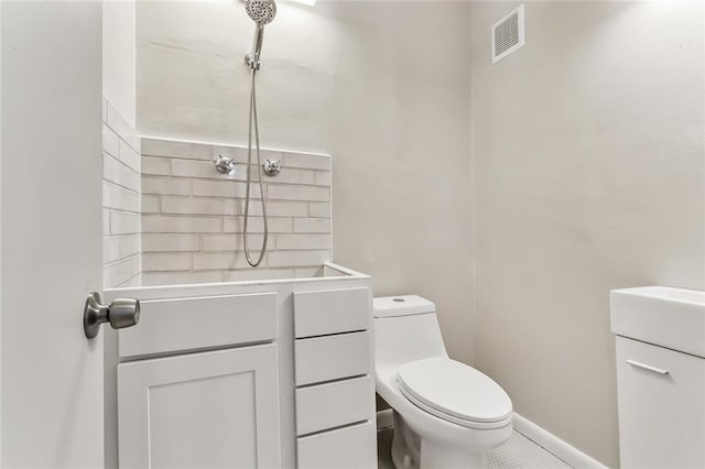 bathroom featuring tile patterned flooring, vanity, and toilet