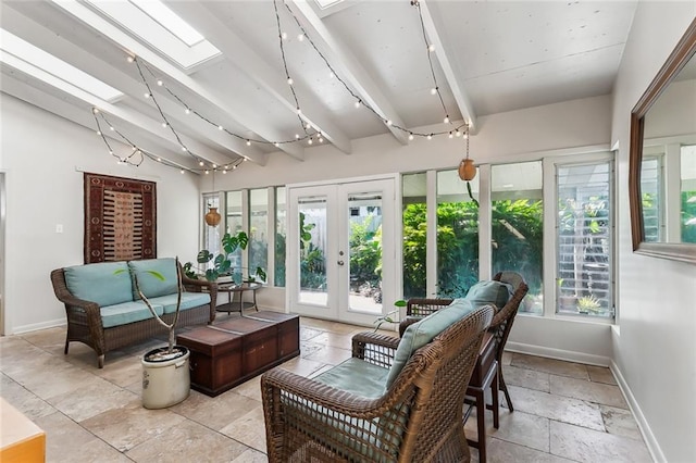 sunroom / solarium with beam ceiling, a skylight, and french doors